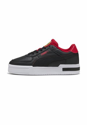 Schwarzer Low-Top-Sneaker mit rotem Innenfutter, rotem Puma-Logo und dicker weißer Sohle auf weißem Hintergrund.