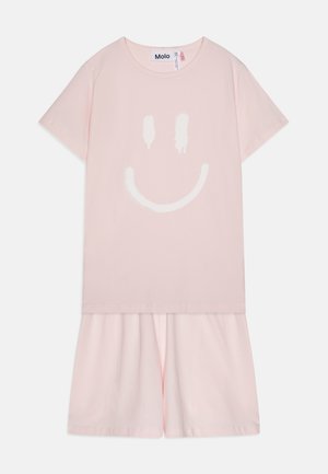 Różowa bawełniana sukienka t-shirt z dużym białym nadrukiem uśmiechniętej buźki, krótkimi rękawami i rozkloszowanym dołem. Miękka, lekka tkanina.