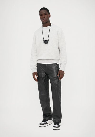 Hallhulest sweatshirt tekstureeritud kangast, mustad nahast cargo püksid, must crossbody kott ja mustad-valged tossud. Lihtne, kaasaegne disain.