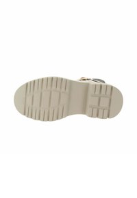 Suola di stivale beige con un motivo di battistrada profondo progettato per la presa, mostrata su uno sfondo bianco.