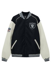 Zwarte en crèmekleurige bomberjack met een Raiders-logo, gestreepte ribgebreide kraag en manchetten, drukknopen aan de voorkant en zijzakken.