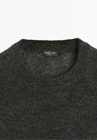 Pull en maille gris foncé avec col rond côtelé et étiquette de marque noire indiquant Massimo Dutti fabriqué en Chine.