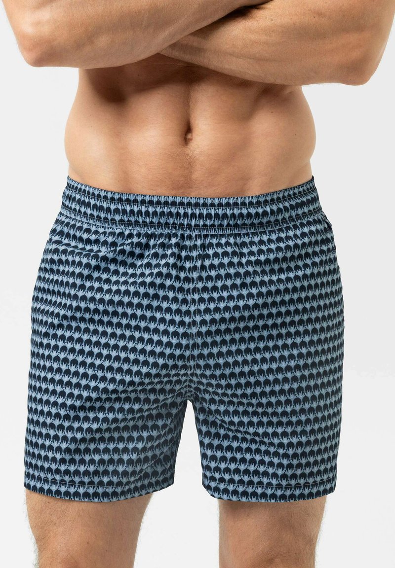 Shorts de bain bleus à motif avec un design répétitif de silhouettes, taille élastique et coupe décontractée. Le matériau semble léger et lisse.