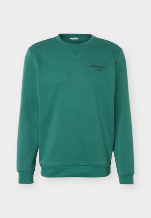 Grüner Sweatshirt mit Rundhalsausschnitt, langen Ärmeln, gerippten Bündchen und dem Schriftzug "BJÖRN BORG STOCKHOLM 1984" auf der linken Brust.