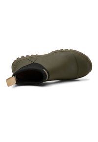 Botte de cheville verte imperméable avec une finition texturée, col élastique noir et tirant beige. Semelle en caoutchouc avec un motif de semelle à crampons.