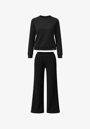 Czarna bluza z długim rękawem i okrągłym dekoltem, z ściągaczami przy rękawach, zestawiona z czarnymi spodniami o szerokich nogawkach, z elastycznym pasem i przednimi szwami.