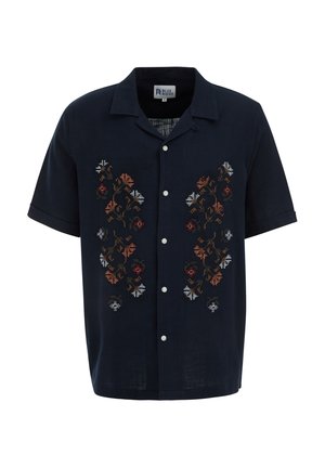 Chemise courte en lin de couleur marine avec des boutons blancs et une broderie florale colorée à l'avant dans des motifs ornés.