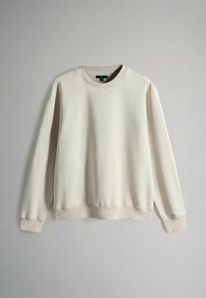 Cremefarvet trøje med rund hals, lange ærmer og ribbede mansjetter. Glat stof, afslappet pasform og minimalistisk design.