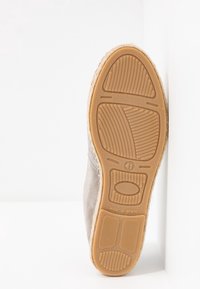 Semelle de chaussure beige de taille 41 avec un profil en caoutchouc texturé et un marquage "Fabriqué en Espagne" sur un fond de coin blanc.