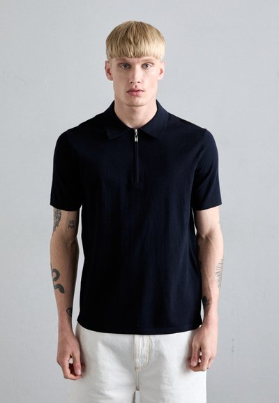 Granatowa koszulka polo z krótkim rękawem i zamkiem z przodu, wykonana z gładkiego materiału. Posiada klasyczny kołnierzyk i minimalistyczny design.