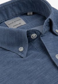 Camisa azul con botones, cuello con solapa, tela texturizada y botones blancos. La etiqueta dice "DAN JOHN REGULAR", talla 15½, 39.