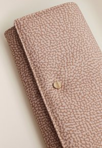 Portafoglio pieghevole in tessuto a righe rosa e beige con cuciture visibili e una piccola chiusura a bottone rotondo dorato su una superficie chiara.