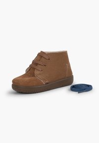 Botas de ante marrón hasta el tobillo con cordones marrones, suela de goma y un cordón azul en contraste a un lado. Presenta detalles de costura y una textura suave.