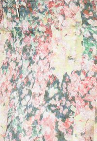 Falda plisada floral en tela ligera que presenta una mezcla de tonos rosas, amarillos y verdes, con una textura suave y un sutil brillo.