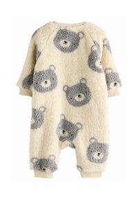 Flis onesie u krem boji s uzorkom sivih medvjedića. Ima raglan rukave i rebraste manžete. Meka, plišasta tekstura pogodna za udobnost.