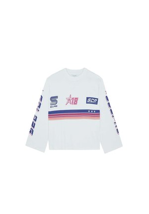 Camiseta de manga larga blanca con estampados gráficos en rosa, azul y rojo, con un patrón de rayas horizontales y acentos de logo en las mangas.