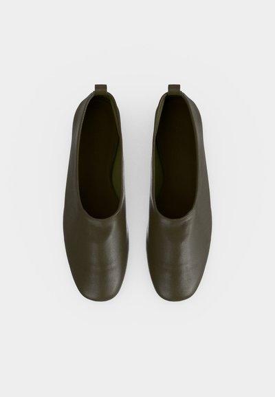 Paire de chaussures en cuir vert olive foncé à enfiler avec des bouts carrés arrondis et de petites languettes à l'arrière, vues de dessus.