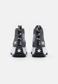 Höga sneakers med grå textilöverdel, vit mellansula, svart texturerad sula med stjärndetaljer och kontrasterande svarta och vita dragband.