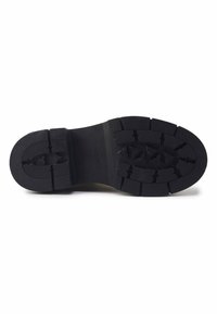 Suela de zapato de goma negra con patrón de agarre texturizado, que presenta surcos profundos y una zona central lisa, marcada con 'NINE WEST' y tamaño '37'.