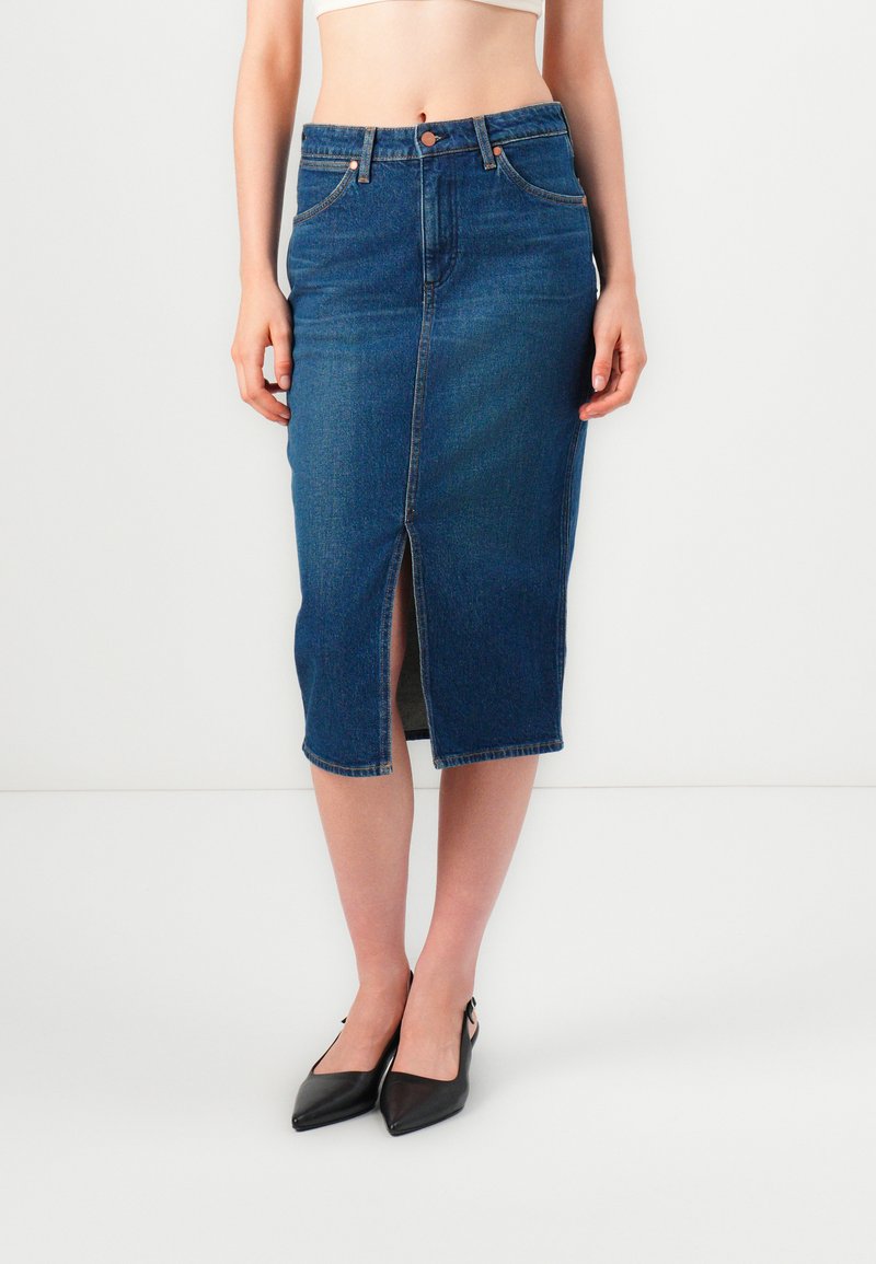 Džinsinės pieštuko sijonas, tamsiai mėlynas, vidutinio ilgio su priekinėmis plyšio detalėmis. Turintis klasikinį penkių kišenių dizainą ir kontrastingą siuvinėjimą. Lengvas audinys.