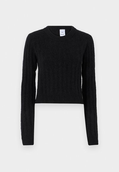 Melnā īsā svītere ar garām piedurknēm, ribota tekstūra un apaļa kakla izgriezums. Izgatavota no mīksta vilnas maisījuma, ar vertikāliem sasuktajiem adījuma rakstiem.