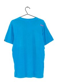 Turkoosi puuvillapaita, jossa on pyöreä kaula-aukko ja lyhyet hihat. Takana kaula-aukon lähellä on vaaleanpunainen logo. Roikkuu mustassa koukussa.