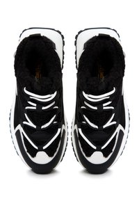 Sneaker alte in bianco e nero, realizzate in tessuto morbido, con sovrapposizioni testurizzate nere, lacci bianchi audaci e una suola in gomma robusta.