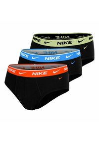 Tres slips negros de Nike con cinturas elásticas en naranja, azul y verde claro, cada uno con el logo y el swoosh de Nike.