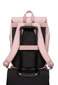 Pink backpack with black accents, featuring padded straps, a top handle, and a rear trolley sleeve for integration with a suitcase.