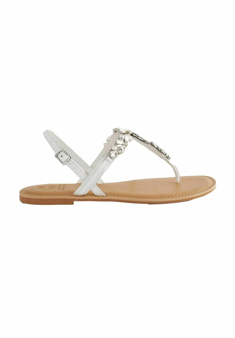 Witte faux leren sandaal met een platte zool, kruisbandontwerp en decoratieve strassaccenten op de bovenkant. Glad tan voetbed.