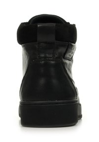 Baskets montantes en cuir noir avec un col en daim, semelle en caoutchouc plate et détails cousus. Présente une étiquette au dos pour l'identification de la marque.