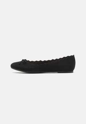 Schwarze Wildleder-Balletschuhe mit gewelltem Rand und einer dekorativen Schleife auf der Zehe. Niedriges Profil und runde Zehenform.