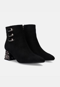 Botines de ante negros con punta afinada, que presentan tres acentos metálicos y un tacón en bloque con un diseño para mayor detalle.