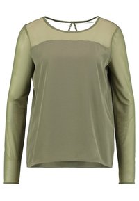 Top a maniche lunghe verde oliva con un corpo in tessuto liscio e maniche trasparenti. Ha un scollo rotondo e un dettaglio a gemello sul retro.