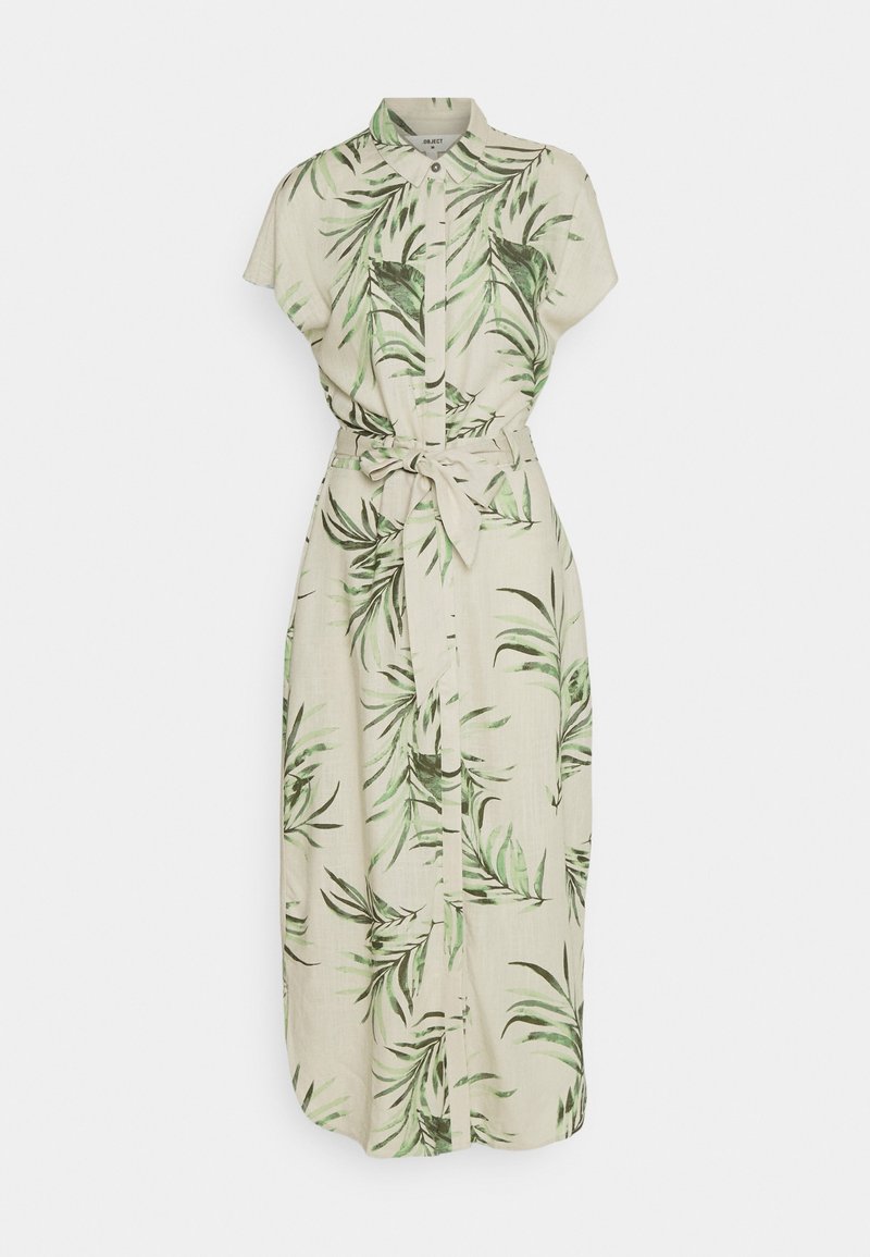 Robe beige clair avec un col, des manches courtes et un motif de feuilles de palmier vertes. Elle présente une fermeture frontale à boutons et une ceinture nouée à la taille.
