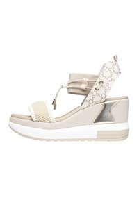 Wedge sandal med en beige mesh-overdel, hvid rem, metallic detaljer og en struktureret platform. Justerbare ankelremme er inkluderet.