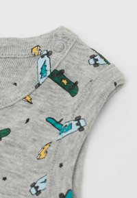 Šedé bavlněné tílko s barevnými grafikami skateboardů, blesky a hvězdami. Zapínání na patentky na rameni.