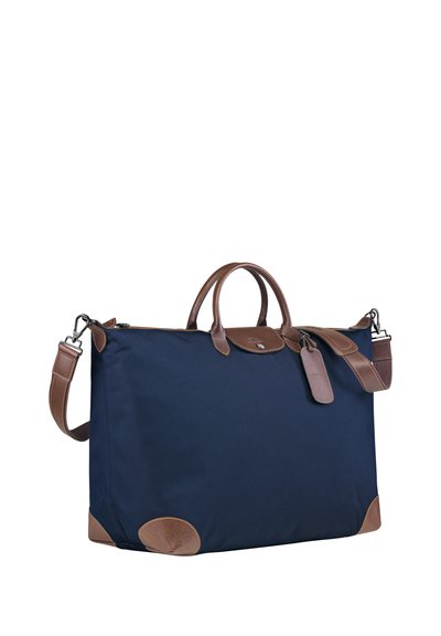 Marineblauer Nylonbeutel mit braunen Lederelementen, rechteckiger Form, doppelten Tragegriffen, abnehmbarem Schultergurt und Lederschild-Detail.