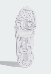 Biela športová podrážka s textúrovanými vzormi, drážkami pre trakciu a kruhovým detailom pri päte. Hladký gumový materiál.