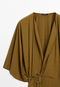 Abito avvolgente verde oliva con maniche a kimono, caratterizzato da una cintura con fibbia circolare e una consistenza del tessuto liscia e fluida.