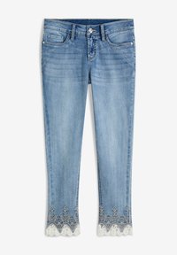 Svetle modré džíny z denimu s přiléhavým střihem, se zakulaceným lemem zdobeným bílou krajkou a květinovými výšivkami.
