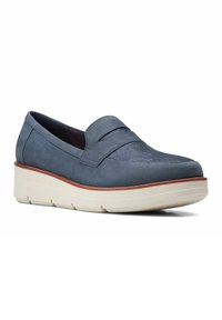 Chaussure slip-on en daim bleu avec un panneau avant texturé, une semelle plateforme blanche surélevée et une bordure marron clair. Finition lisse dans l'ensemble.