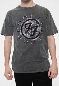 Gray cotton T-shirt with short sleeves, featuring a circular black and purple graphic design at the center, including stylized letters.