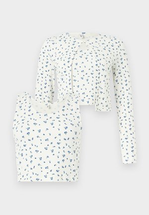 Σετ λευκό ριγέ φανελάκι και κοντή ζακέτα με μικρό μπλε λουλουδάτο σχέδιο, μακριά μανίκια στη ζακέτα, στρογγυλές λαιμόκοψεις.