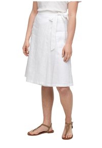 Witte linnen wikkelrok, knie-lang met een gestrikt middel, kenmerkt zich door een soepele textuur en een minimalistisch ontwerp. Gecombineerd met een paar bruine platte sandalen.