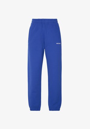 Pantaloni della tuta blu con vita elasticizzata, due tasche laterali e polsini elastici alle caviglie. Presenta testo stampato bianco sul davanti.