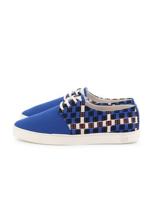 Paire de baskets basses en toile bleue avec semelles blanches, lacets blancs et motif à damier noir, bleu et marron sur les côtés.