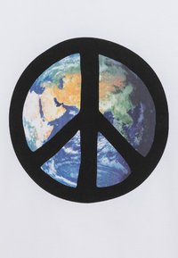 Valkoinen t-paita, jossa on suuri musta rauhansymboli. Sen sisällä on värikäs kuva maapallosta, jolta näkyy maata ja meriä.