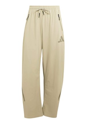 Beige Hosen mit weitem Bein, elastischem Bund, Kordelzug, seitlichen Reißverschlusstaschen und dezentem Logo am rechten Oberschenkel.