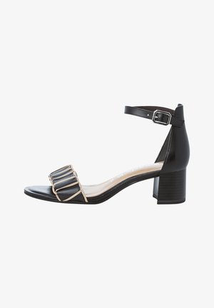 Czarne skórzane sandały na słupku, z beżowym detalem na pasku i szeroką opaską na palcach z pionowymi rowkami. Pasy na kostkę z klamrą.